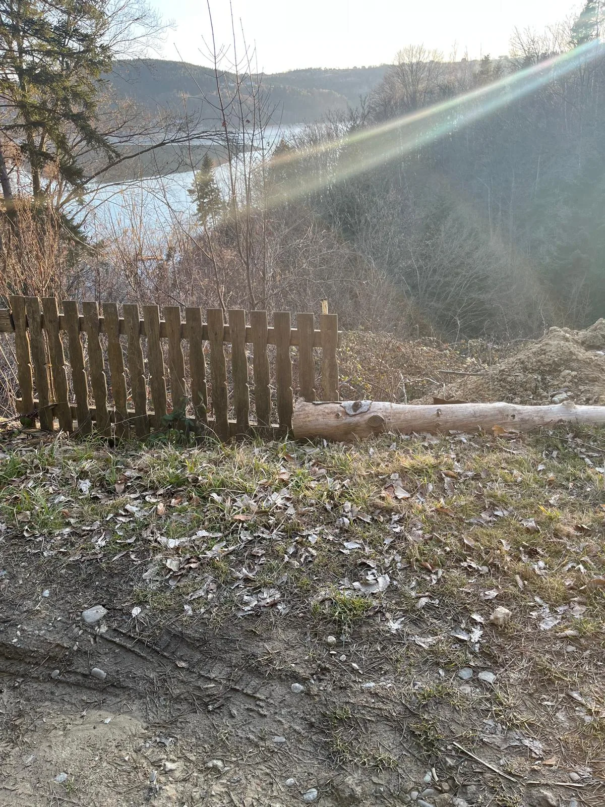 Drewniany płot na zboczu działki z widokiem na jezioro w okolicach Nowego Sącza
